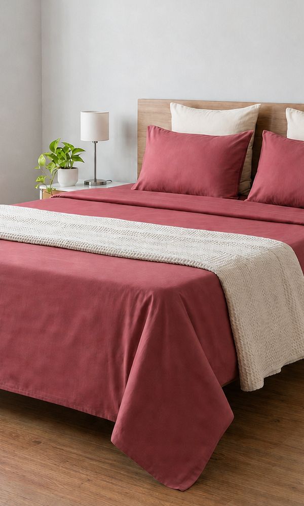 Maroon bedsheet as shown on a website, smooth and neatly spread